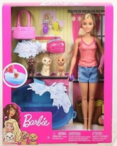Barbie-Puppe mit Zubehör und drei Hunden in einer Spielzeugverpackung.