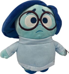 Blaue Plüschfigur mit Brille und melancholischem Ausdruck.
