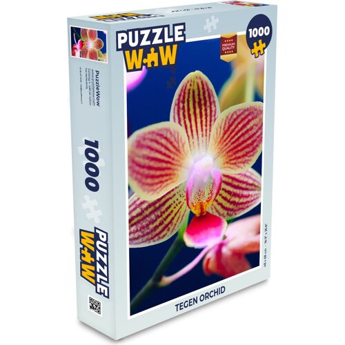 Puzzleverpackung mit Orchideenmotiv und 1000 Teilen, bunte Blume auf blauem Hintergrund. Puzzleverpackung mit Orchideenmotiv und 1000 Teilen, bunte Blume auf blauem Hintergrund.